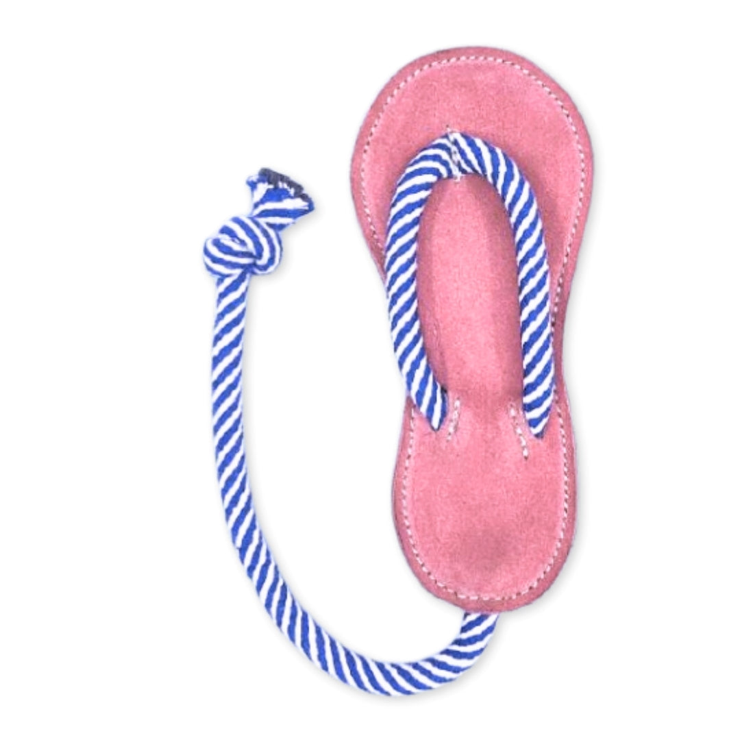 A single Georgie Paws pink Jandal with blue and white striped straps lies against a white background, its mate seemingly absent. It is now repurposed as an earth-friendly chew toy for puppies.