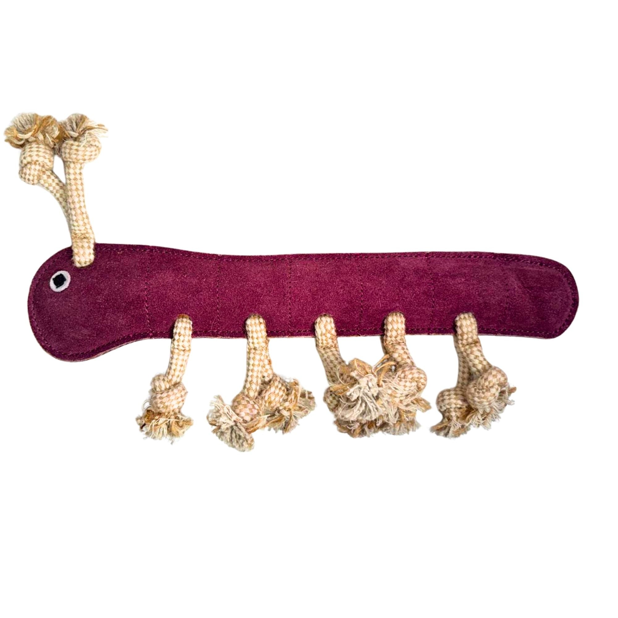 Gerti the Grub – purple by Georgie Paws is a sustainable plush dog toy shaped like a centipede, featuring maroon suede fabric, a white embroidered eye, and six tan rope legs with knotted tassels, ideal for playful pups.