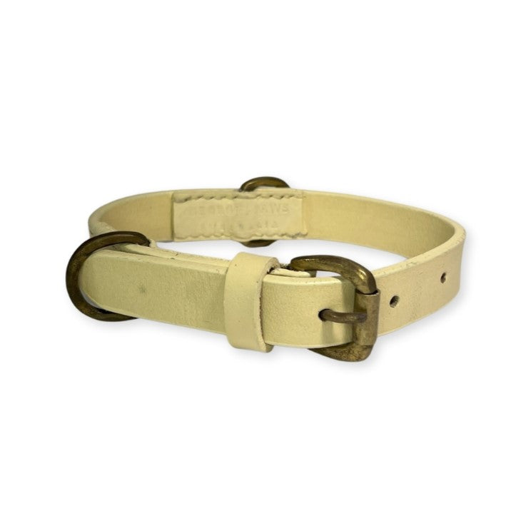 A handcrafted cream-colored Georgie Paws buffalo leather collar with a metal buckle and d-ring, possibly for a small pet, shown against a white background. The collar appears to have text embossed on it.