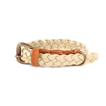 The Windsor Collar - Chalk by Georgie Paws is crafted from beige buffalo leather, braided and coiled on a white background. It includes a bronze buckle and an orange keeper loop, providing adjustable sizing and a chic yet casual contrast to the light-colored design.