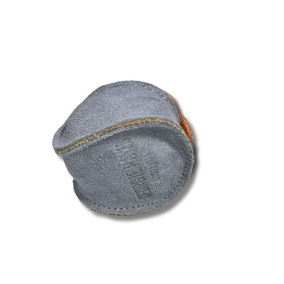 A worn-out Georgie Paws Chambray tennis ball with faded stitches and scuffed surface, isolated on a white background, showing signs of heavy use and age.