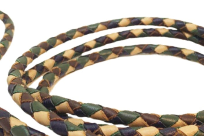 The Windsor Lead - Bushland by Georgie Paws is a braided dog leash made with tan, brown, and green buffalo leather. It features a looped handle with handmade brass hardware and has a tan leather tag near the handle embossed with "GEORGIE PAWS," showcasing its signature design.