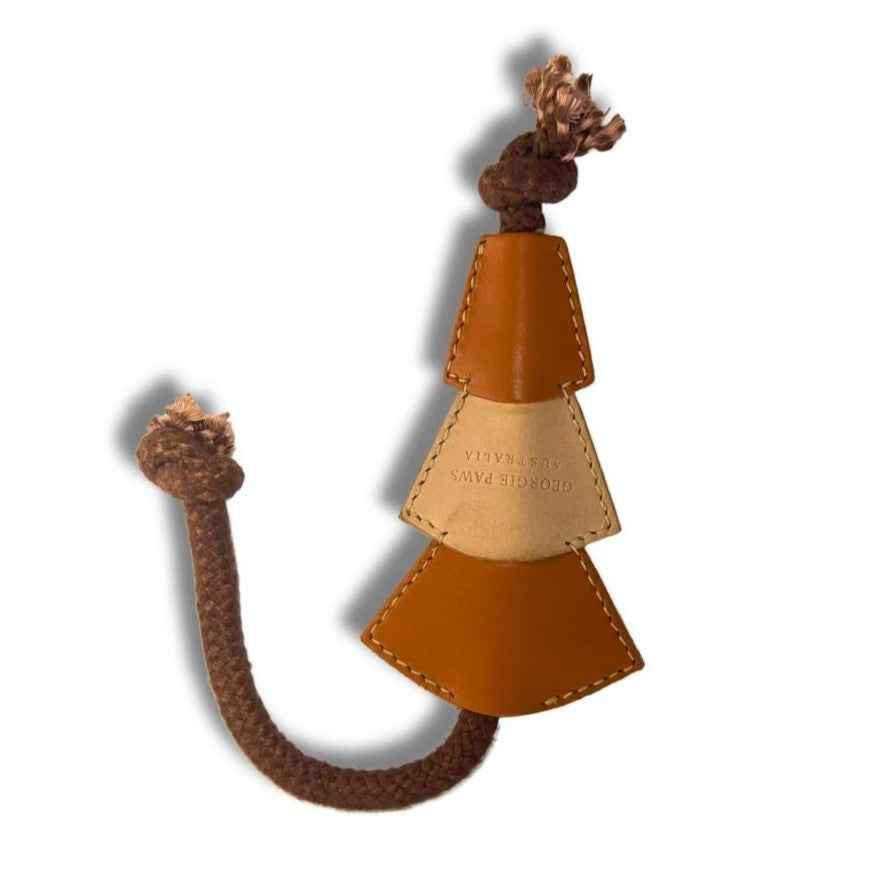 A whimsical Bush Christmas Chew Toy - ochre from Georgie Paws, made of Veg-Tanned Buffalo Leather and braided rope, resembling an abstract tree or figure on a white background, with intricate stitching and embossed details.
