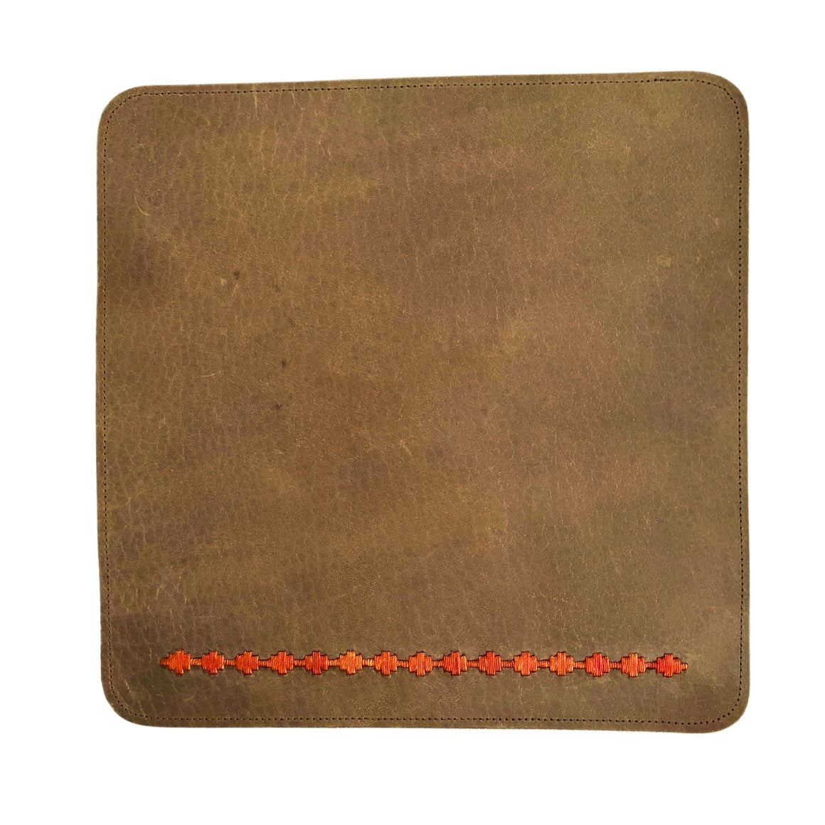 A worn brown Buffalo leather dinner mat with stitched edges, featuring a row of small, embossed red flowers along the lower edge. The surface shows slight marks and variations in color typical of used leather by Georgie Paws.