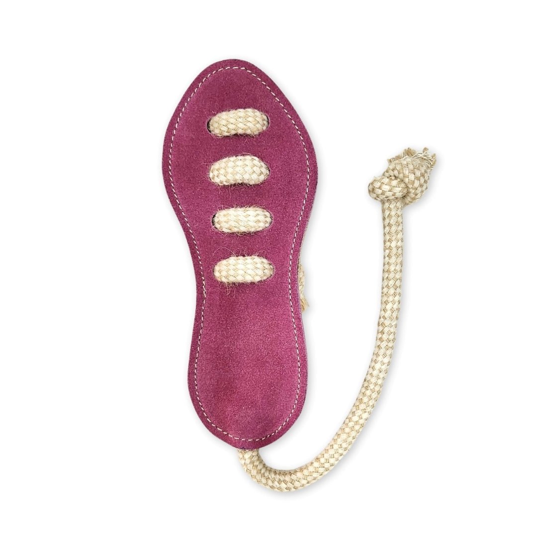 Introducing the Footy Boot - Hot Pink from Georgie Paws: This maroon suede shoe sole, crafted from sustainable, vegetable-tanned buffalo leather, is adorned with four beige laces threaded across the middle and a long natural beige rope attached to one end, knotted at the tip. The product is set against a white background.