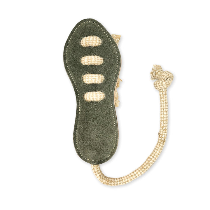 The Georgie Paws Footy Boot - Chive is a green oval dog toy with a suede-like texture, eco-friendly materials, three horizontal ropes woven through the center, and a knotted rope loop for tossing or tugging.