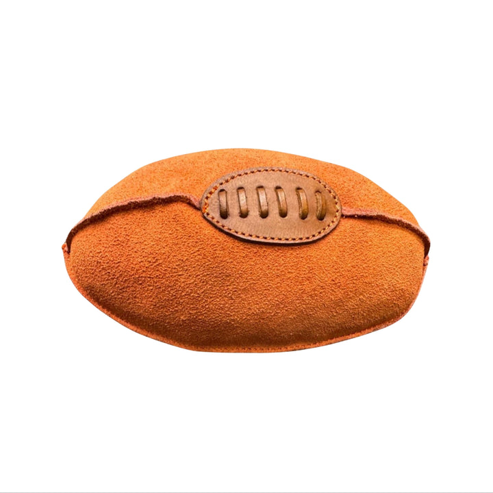The Georgie Paws Footy - orange is a plush buffalo suede dog toy shaped like an American football, featuring soft orange-brown fabric and a stitched brown patch for laces, shown on a plain white background.