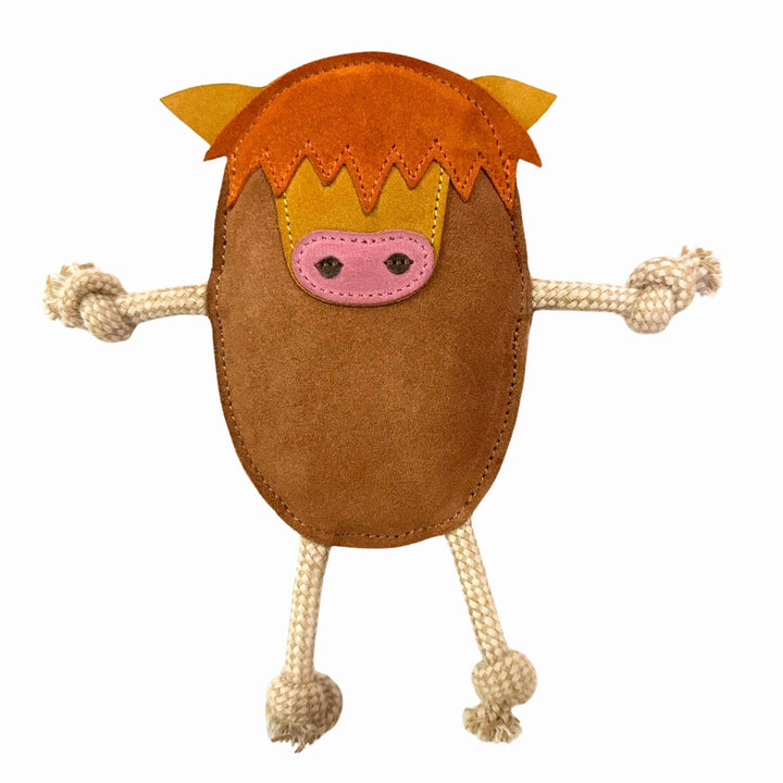 Hector the Highland Cow Dog Toy by Georgie Paws is a plush toy shaped like a brown cow, featuring orange felt hair, yellow felt ears, a pink felt snout, and beige rope arms and legs tied at the ends. Made with sustainable materials, it is displayed against a plain white background.
