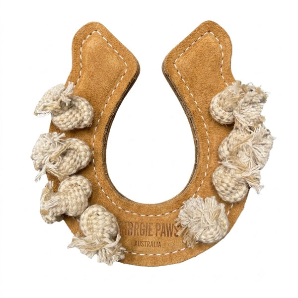 A tan horseshoe-shaped dog toy from Georgie Paws, called the “Horseshoe Dog Toy – Pink & Tan,” is crafted from a suede-like material with white stitching for durability. Cream rope knots are attached along the outer edge, adding texture for chewing. The toy features the label “Pawgie Paws Australia” near the bottom center and is displayed against a plain white background.