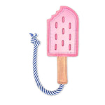 A pink Icy Pole popsicle-shaped fabric bookmark with a blue and white striped string, designed to mark one's place in a book with a whimsical touch, now made of compostable materials by Georgie Paws.