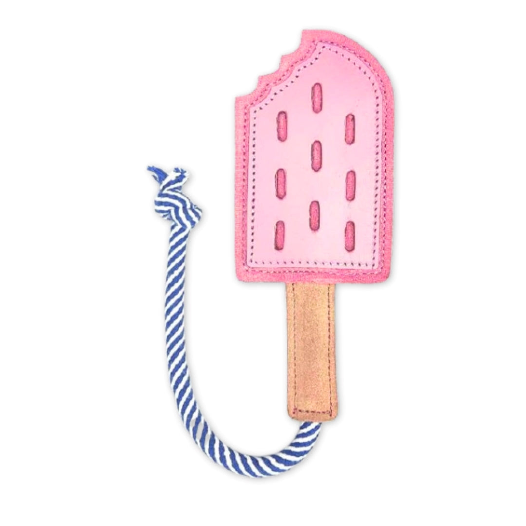 A pink Icy Pole popsicle-shaped fabric bookmark with a blue and white striped string, designed to mark one's place in a book with a whimsical touch, now made of compostable materials by Georgie Paws.