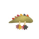 The Larry Lizard - rainbow by Georgie Paws is an eco-friendly, green felt dinosaur-shaped baby toy. It features colorful felt spikes along its back and three pairs of star-shaped felt feet hanging from its underside in pink, yellow, and black, attached by beige string. The toy boasts a simple, playful design and a soft texture.