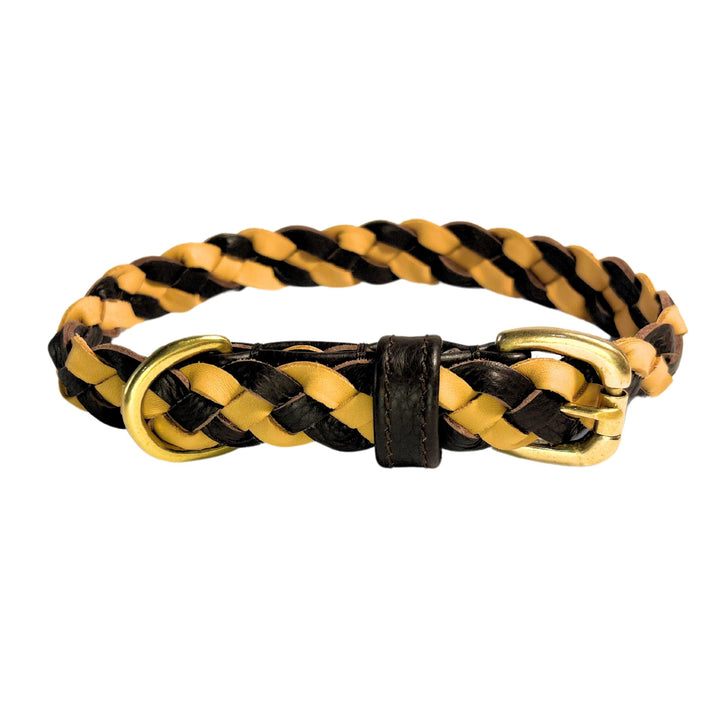 The LuLu Collar - Chicory by Georgie Paws is a braided leather accessory made from Buffalo Leather. It features alternating black and tan strips, a brass buckle, and a single black belt loop that adds charm against a white background.