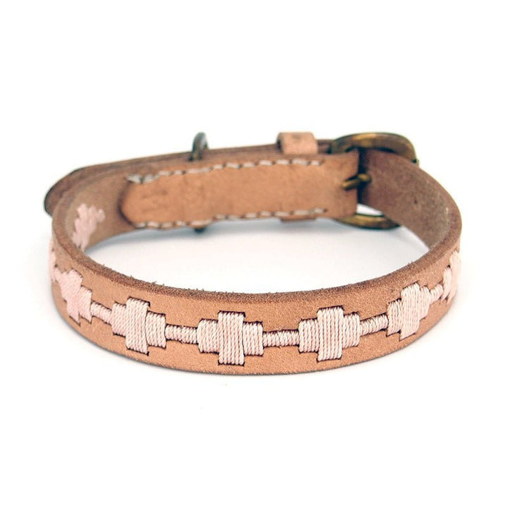 The Ethel Collar - Carnation by Georgie Paws is a handmade light brown collar crafted from natural vegetable-tanned buffalo leather, featuring cream zigzag cross-stitch embroidery, a small brass buckle, and two adjustment holes. Shown on a white background.