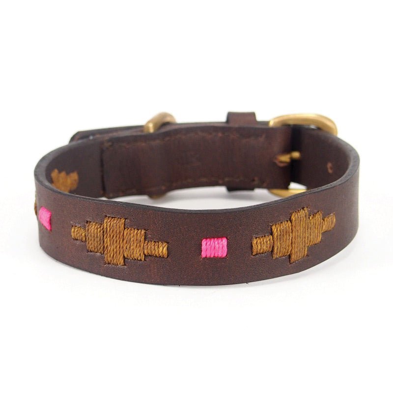 The Polo Collar - Mage by Georgie Paws is a dark brown handmade leather dog collar adorned with gold square and diamond-stitched patterns and delicate pink square stitches. Featuring a brass buckle and hardware, this collar is shown against a white background.