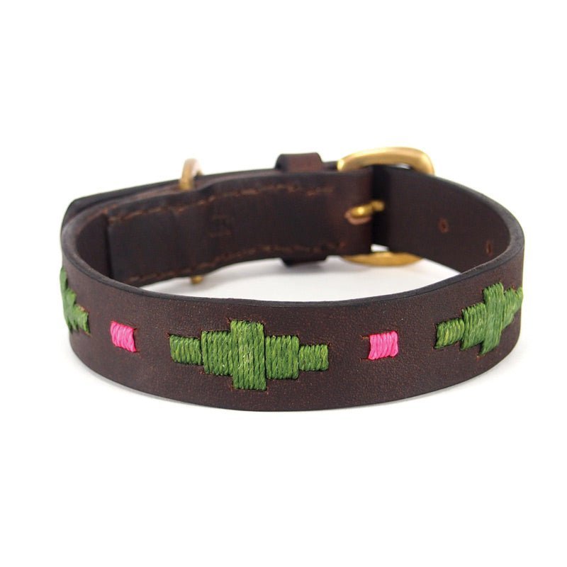 Introducing the Polo Collar - Myrtle by Georgie Paws. This sturdy, sustainable, and adjustable dog collar is crafted from dark brown, vegetable tanned buffalo leather with a smooth finish. It features a gold-colored buckle and is adorned with green geometric stitching, accented by subtle pink stitched lines.